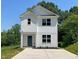 Charming two-story home with white siding, a blue front door, and a concrete driveway at 112 Remington Woods Dr, Wake Forest, NC 27587