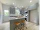Modern gray kitchen with stainless steel appliances, granite countertops, an island, and wood stools at 112 Remington Woods Dr, Wake Forest, NC 27587