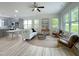 Bright, open-concept living area with lots of natural light, ceiling fan, and modern furnishings at 112 Remington Woods Dr, Wake Forest, NC 27587