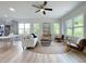 Bright, open-concept living area with lots of natural light, ceiling fan, and modern furnishings at 112 Remington Woods Dr, Wake Forest, NC 27587