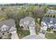 Aerial view of an upscale neighborhood showcasing the home's location with mature trees and manicured lawns at 113 Woodland Ridge Ct, Cary, NC 27519
