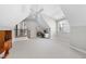Bright, spacious attic with carpet, a ceiling fan, and a built-in desk area by the window for a comfortable workspace at 113 Woodland Ridge Ct, Cary, NC 27519