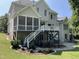 Well-maintained backyard featuring a screened porch, raised deck, patio area, and manicured lawn at 113 Woodland Ridge Ct, Cary, NC 27519