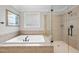 Luxurious bathroom showcases a large soaking tub, a separate glass-enclosed shower, and neutral tile surround at 113 Woodland Ridge Ct, Cary, NC 27519