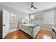 Bright bedroom with hardwood floors features a ceiling fan and tranquil backyard views at 113 Woodland Ridge Ct, Cary, NC 27519