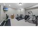 Well-equipped exercise room features a variety of equipment and a television for entertainment at 113 Woodland Ridge Ct, Cary, NC 27519