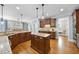 Bright kitchen featuring an island, custom cabinetry, granite countertops, and stainless steel appliances at 113 Woodland Ridge Ct, Cary, NC 27519