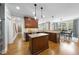 Well-appointed kitchen with an island, custom wood cabinets, granite countertops, and a view into the dining room at 113 Woodland Ridge Ct, Cary, NC 27519