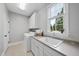 Well-lit laundry room with modern washer and dryer, white cabinets, sink, and a window at 113 Woodland Ridge Ct, Cary, NC 27519