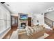 Inviting living room features a stone fireplace, hardwood floors, comfortable seating, and easy access to stairs at 113 Woodland Ridge Ct, Cary, NC 27519