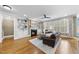 Bright living room features built-in bookshelves, fireplace, hardwood floors, ceiling fan, and a leather sofa at 113 Woodland Ridge Ct, Cary, NC 27519