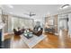 Cozy living room features a ceiling fan, hardwood floors, a brown leather sofa and view into the dining area at 113 Woodland Ridge Ct, Cary, NC 27519