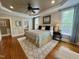 Main bedroom showcasing a ceiling fan, hardwood floors, ensuite bathroom and a large bed at 113 Woodland Ridge Ct, Cary, NC 27519