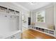 Mudroom with coat rack, storage bench, tile flooring, and view into laundry room at 113 Woodland Ridge Ct, Cary, NC 27519