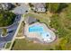 Aerial view of a community pool with a unique design, surrounded by lush greenery and nearby homes at 113 Woodland Ridge Ct, Cary, NC 27519