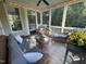 Relaxing screened porch featuring wicker furniture, string lights, and a ceiling fan at 113 Woodland Ridge Ct, Cary, NC 27519