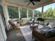 Inviting screened porch featuring wicker furniture, string lights, and a ceiling fan at 113 Woodland Ridge Ct, Cary, NC 27519