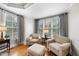 Bright sitting area with hardwood floors, neutral furniture, and large windows with blinds at 113 Woodland Ridge Ct, Cary, NC 27519