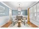 Comfortable sitting room features blue walls, white trim, plantation shutters, a pendant light and wood floors at 113 Woodland Ridge Ct, Cary, NC 27519