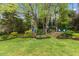 A well-maintained backyard featuring mature trees and beautiful landscaping at 1205 Country Ridge Dr, Raleigh, NC 27609
