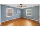 Bedroom with a ceiling fan, hardwood floors, and large windows for natural light at 1205 Country Ridge Dr, Raleigh, NC 27609