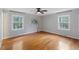Bright bedroom with hardwood floors, natural light from two windows, and a ceiling fan at 1205 Country Ridge Dr, Raleigh, NC 27609