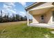 Covered back porch looking out onto an expansive green lawn and bordering woods at 122 Wilderness Trl, Smithfield, NC 27577