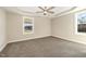 A spacious bedroom featuring a tray ceiling with a ceiling fan and two windows at 122 Wilderness Trl, Smithfield, NC 27577