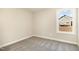 An empty bedroom featuring neutral walls, plush carpeting, and a window offering outside views at 122 Wilderness Trl, Smithfield, NC 27577