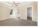A spacious bedroom featuring a tray ceiling with a ceiling fan, a window, and access to the bathroom at 122 Wilderness Trl, Smithfield, NC 27577