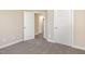 An empty bedroom featuring neutral walls, plush carpeting, and two white doors at 122 Wilderness Trl, Smithfield, NC 27577