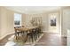 A dining room with vinyl floors, window, an exterior door, a wooden table and black chairs at 122 Wilderness Trl, Smithfield, NC 27577