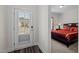 Cozy bedroom showcasing a view to the exterior and decorated with a red comforter and multiple pillows at 1241 White Flint Cir, Durham, NC 27703
