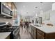Open kitchen with stainless steel appliances, center island, and view into dining and living areas at 1241 White Flint Cir, Durham, NC 27703