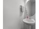 Bathroom featuring a pedestal sink, round mirror, and neutral wall paint at 125 Paperwhite Pl, Clayton, NC 27527