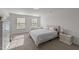 Bright bedroom with two large windows, neutral carpeting, and a comfortable bed with bedside tables at 125 Paperwhite Pl, Clayton, NC 27527