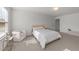 Sun-filled bedroom features a comfortable bed, accent chair, neutral walls, and plush carpeting at 125 Paperwhite Pl, Clayton, NC 27527