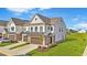 Beautiful townhome with white siding, brick accents, and a two-car garage, complemented by a well-manicured lawn at 125 Paperwhite Pl, Clayton, NC 27527