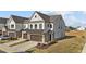 Charming townhome featuring a two-car garage, modern architectural details, and professional landscaping at 125 Paperwhite Pl, Clayton, NC 27527