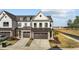 Attractive townhome showing a two-car garage, brick accents, and a neatly landscaped yard at 125 Paperwhite Pl, Clayton, NC 27527