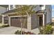 Side view of a new construction townhouse with a brick facade, two-car garage and professional landscaping at 125 Paperwhite Pl, Clayton, NC 27527