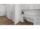 Hallway with a built-in desk, white cabinets, and wood floors at 125 Paperwhite Pl, Clayton, NC 27527