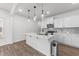 Bright kitchen with white cabinets, stainless appliances, hardwood floors and quartz countertops with a center island at 125 Paperwhite Pl, Clayton, NC 27527