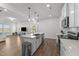 Bright and open kitchen with white cabinets, quartz counters, stainless appliances, hardwood floors and recessed lighting at 125 Paperwhite Pl, Clayton, NC 27527