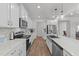 Open kitchen design with white cabinets, quartz counters, stainless appliances and hardwood floors at 125 Paperwhite Pl, Clayton, NC 27527