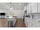 Bright and open kitchen with white cabinets, stainless steel appliances, an island and a breakfast bar at 125 Paperwhite Pl, Clayton, NC 27527