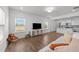 Bright living room features hardwood floors, large windows, and an open layout to the kitchen at 125 Paperwhite Pl, Clayton, NC 27527
