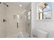 Modern shower featuring neutral tiling, glass door, sleek fixtures, and recessed shelving niche at 125 Paperwhite Pl, Clayton, NC 27527