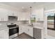 Modern kitchen featuring stainless steel appliances, white cabinetry, and granite countertops at 125 Prosecco Dr, Princeton, NC 27569