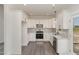 Modern kitchen featuring stainless steel appliances, white cabinets, and granite countertops at 125 Prosecco Dr, Princeton, NC 27569